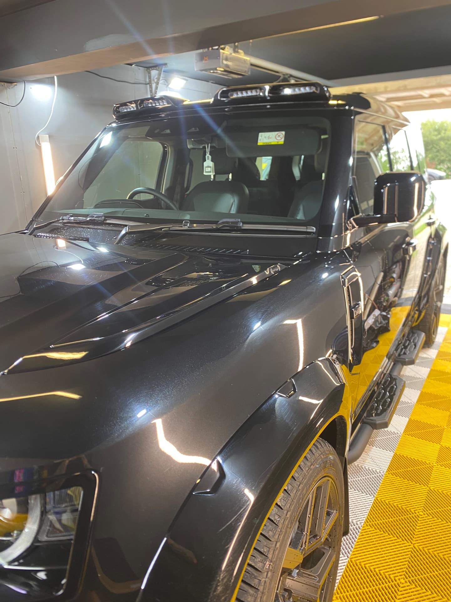Black Land Rover Defender with roof light bar detailed in the unit