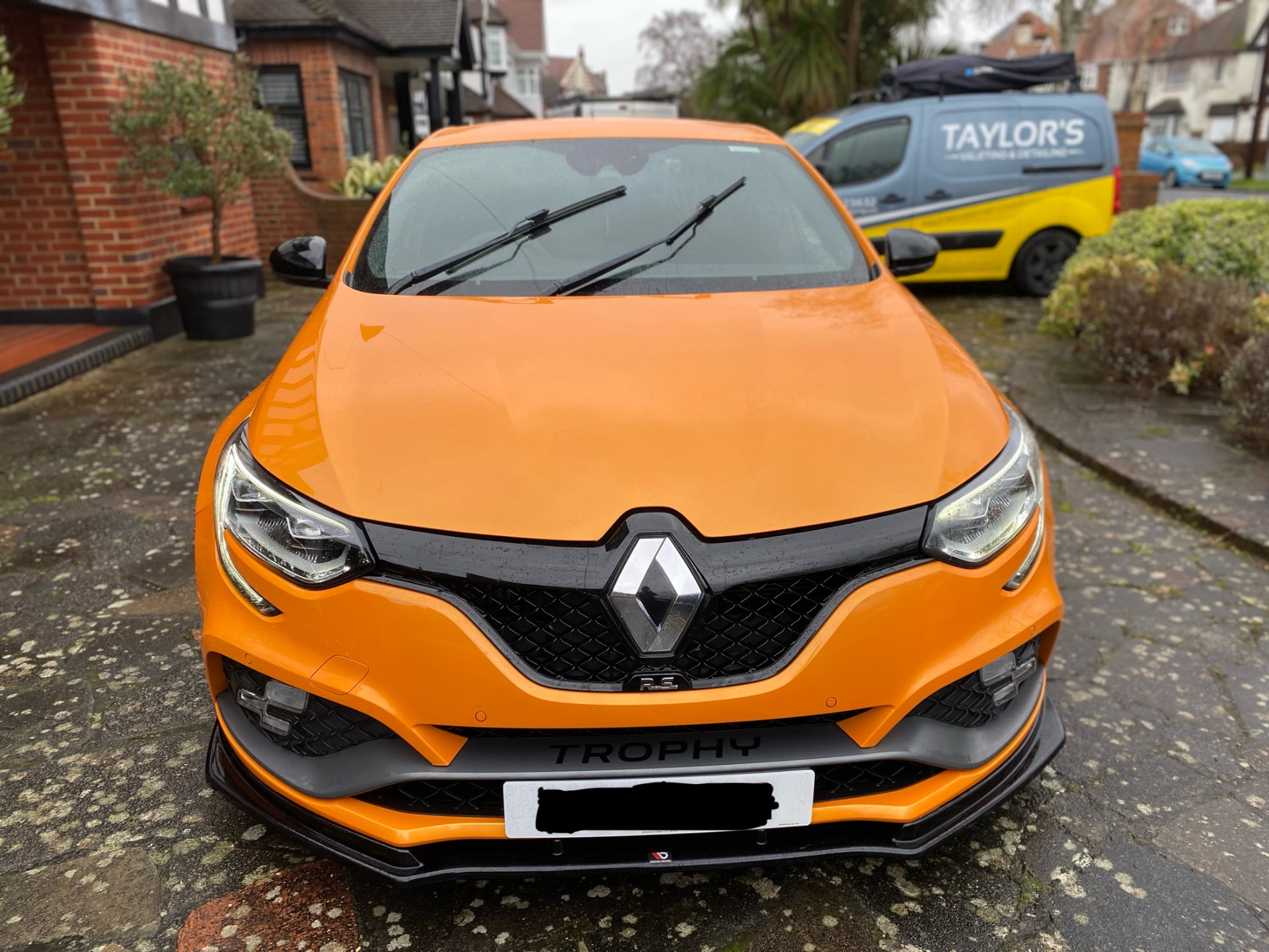 Orange Renault Megane RS Trophy valeted on a driveway beside the Taylor's van