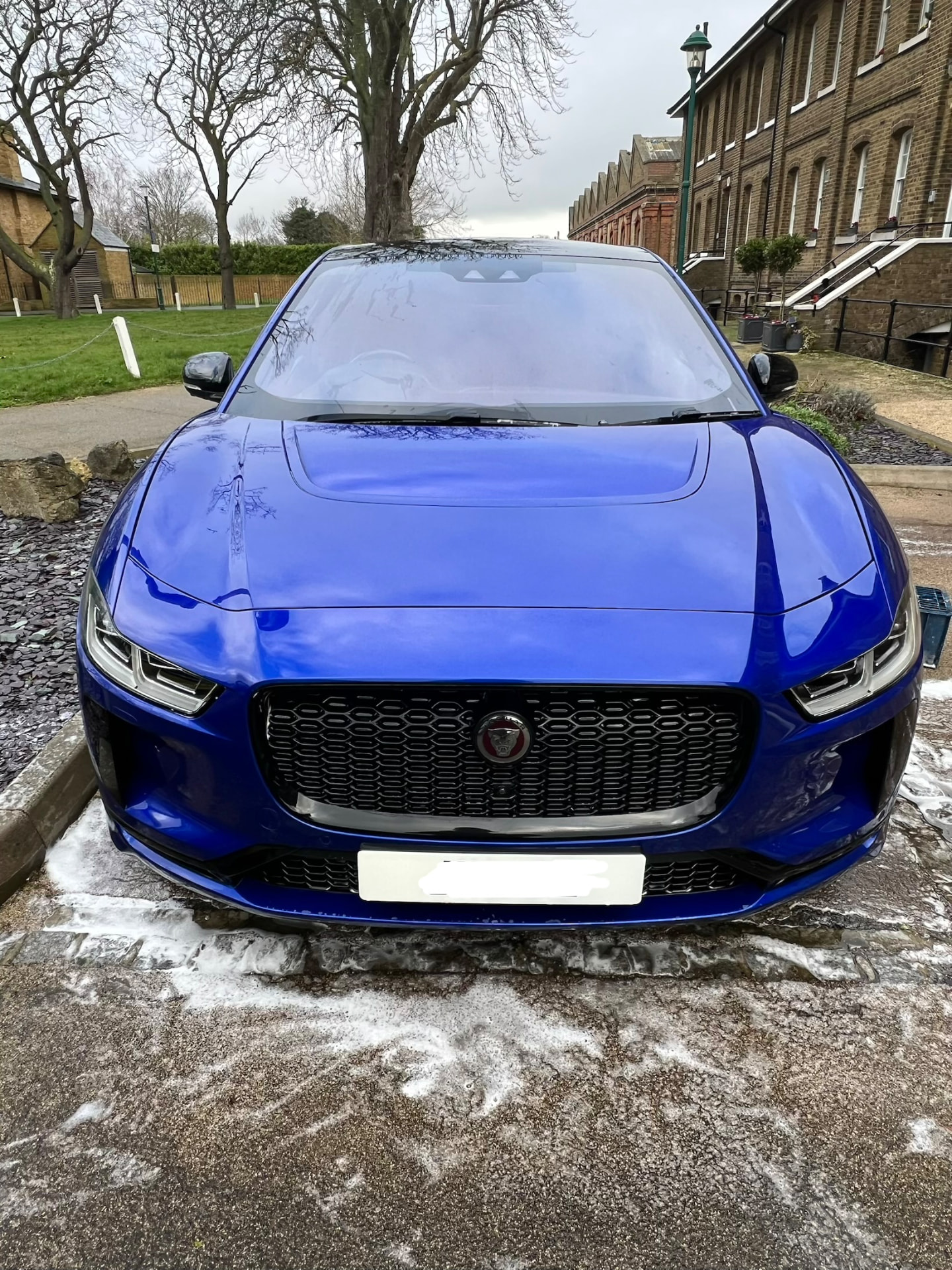 Blue Jaguar I-Pace washed to a deep gloss finish on a courtyard driveway