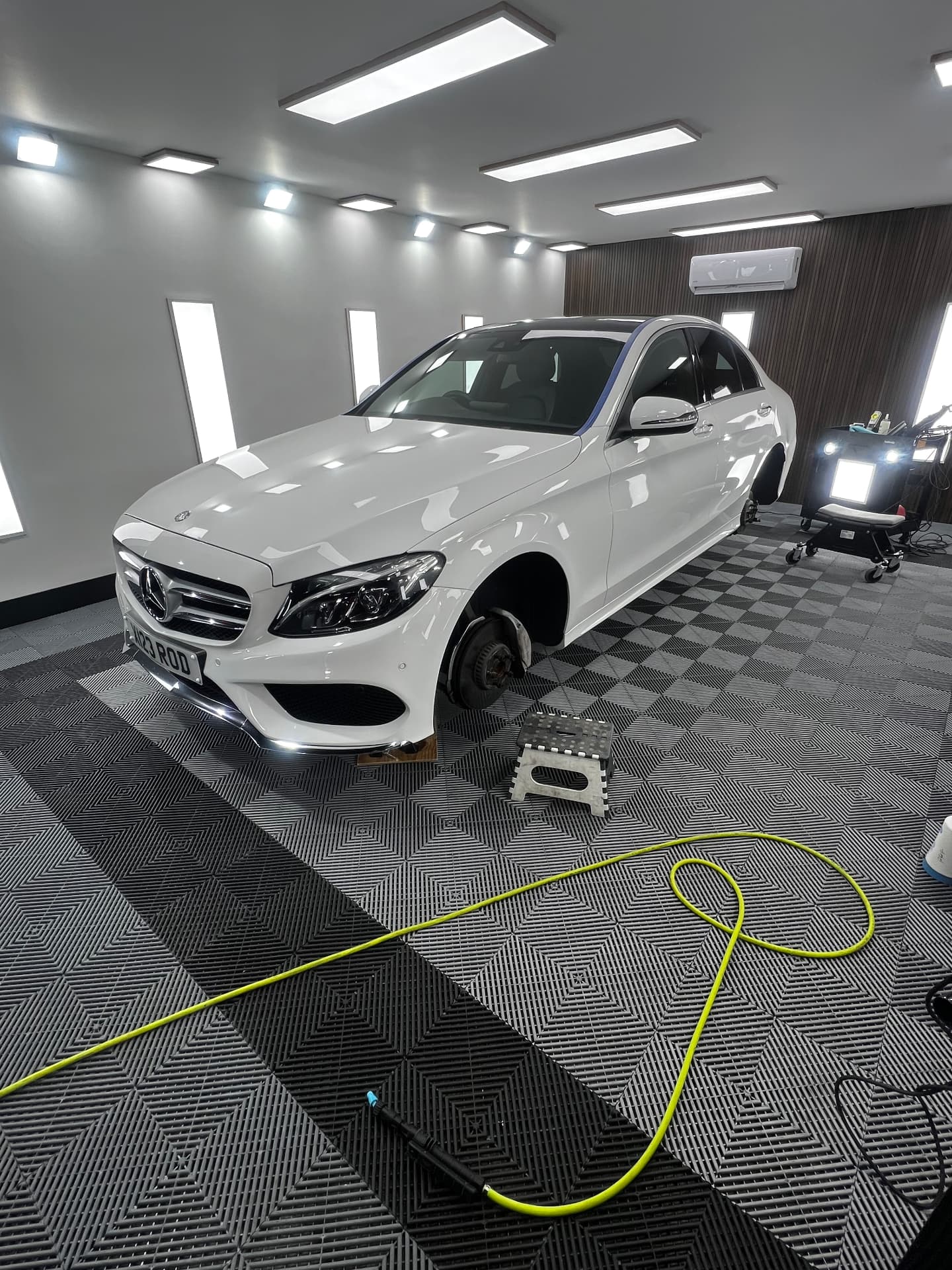 White Mercedes C-Class on jack stands mid-detail in the Daws Heath unit