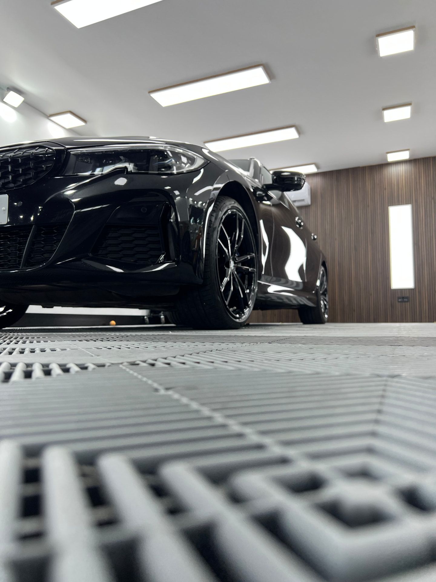 Low angle of a black BMW with a mirror-gloss finish inside the detailing unit