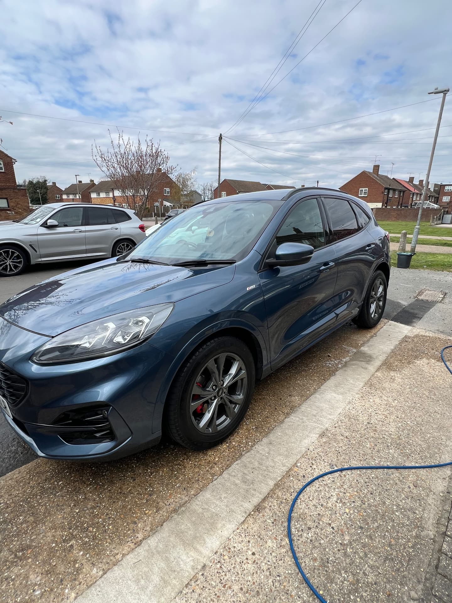 Blue Ford Kuga ST-Line washed and polished outside a customer's home