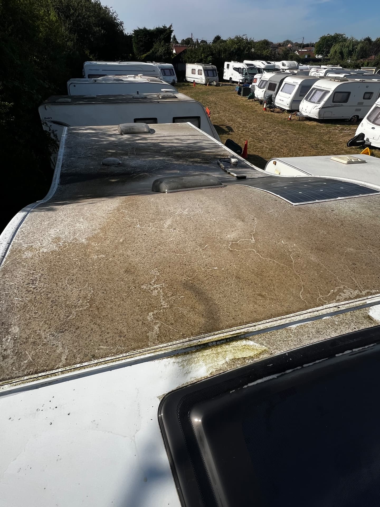 Caravan roof heavily soiled with green algae and dirt before cleaning