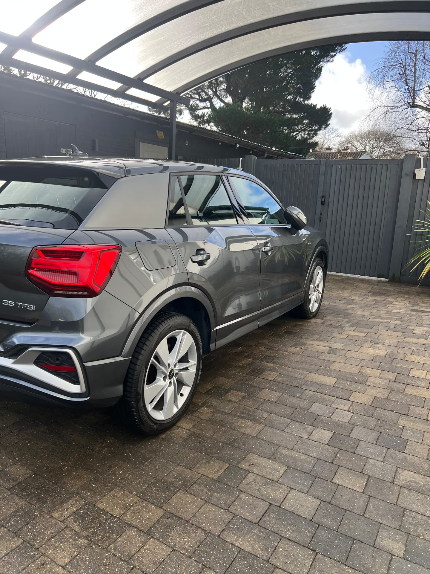 Grey Audi Q2 S line cleaned and polished under a carport