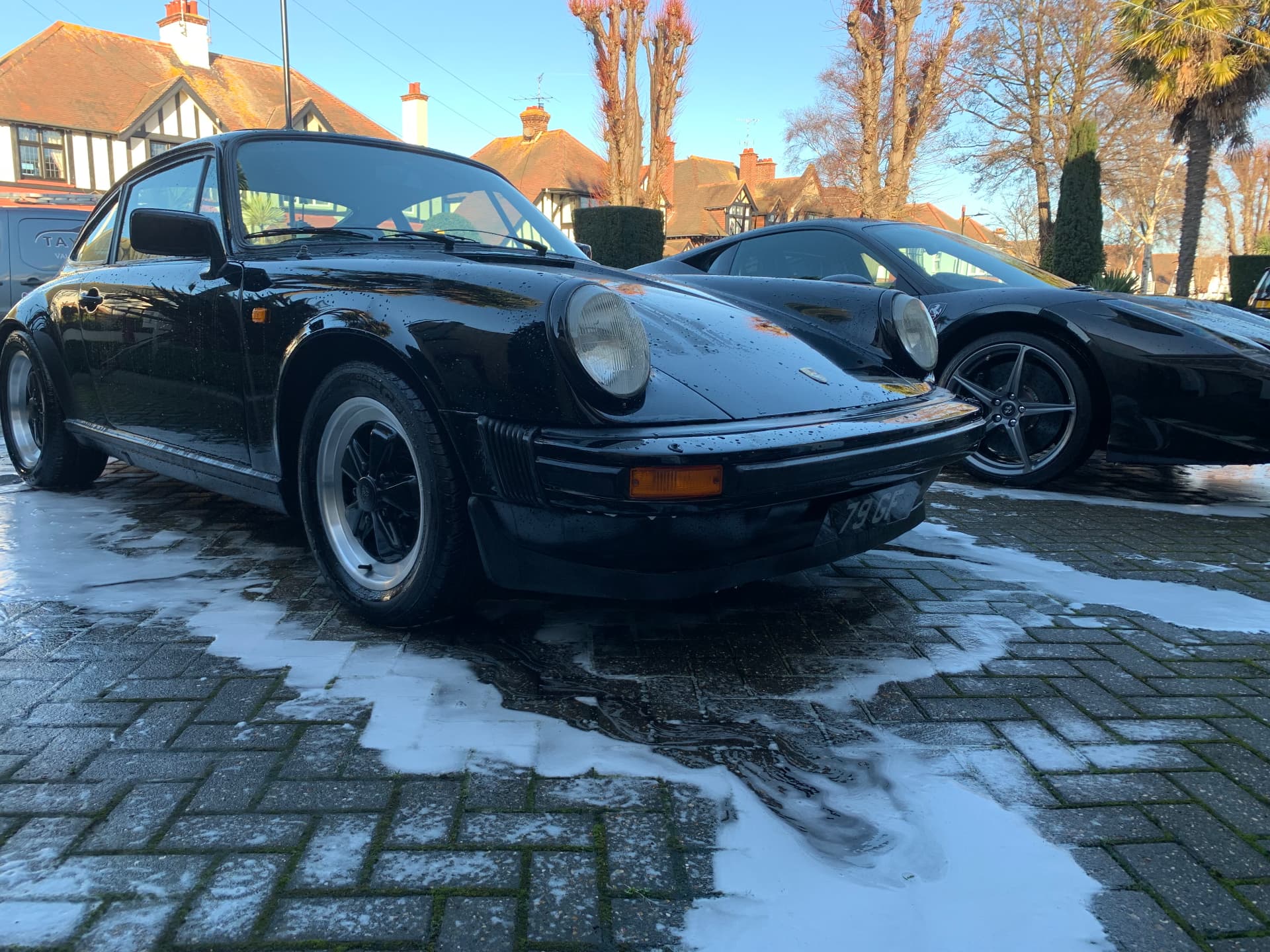 Black classic Porsche 911 washed to a deep gloss on a driveway
