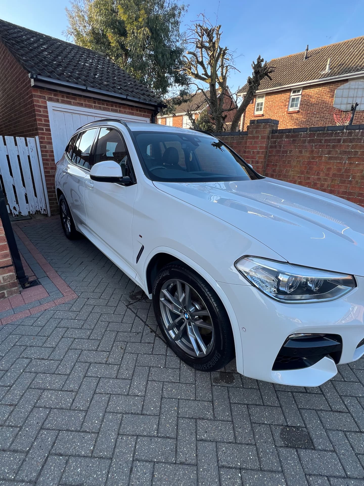 White BMW X3 M Sport polished to a bright finish on a block driveway