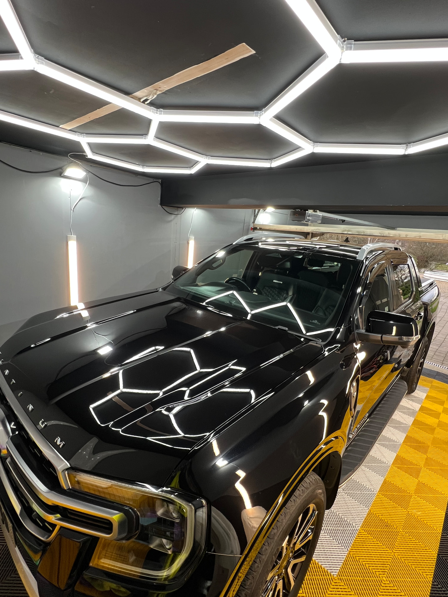 Black Ford Ranger Platinum reflecting hex lighting after a gloss detail