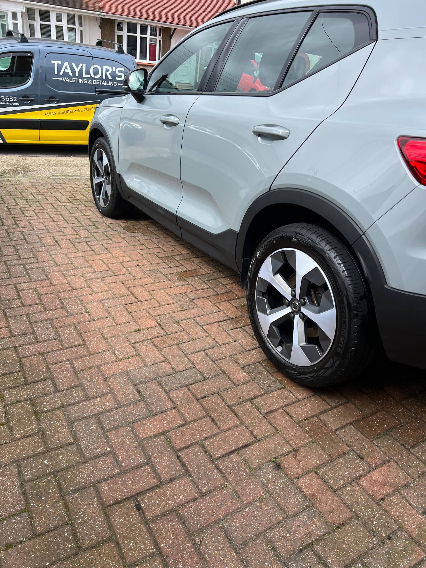 Grey Volvo XC40 cleaned on a driveway beside the Taylor's valeting van