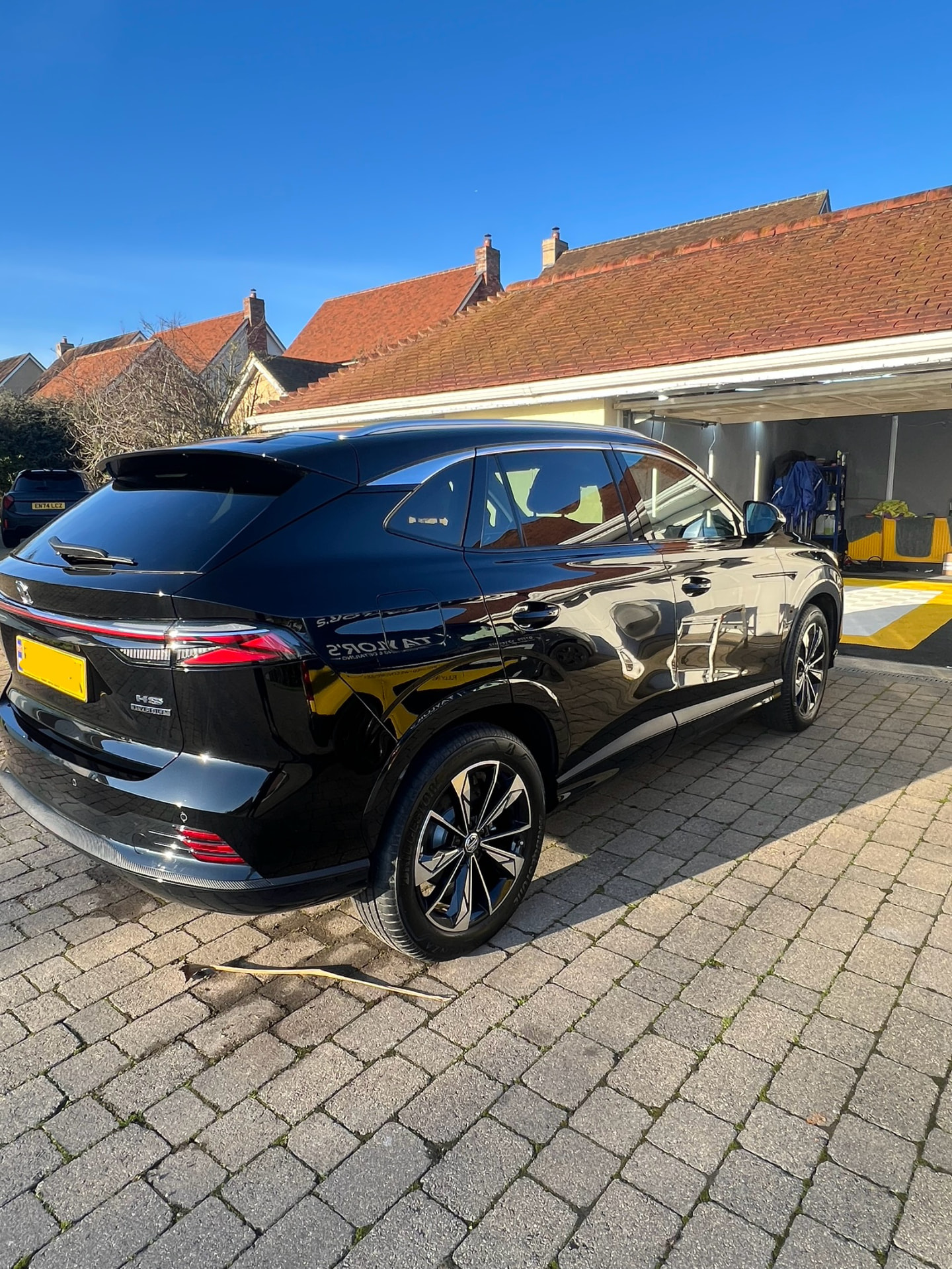 Black MG HS Hybrid gleaming on a block-paved driveway after a full valet